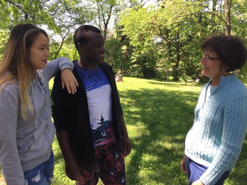 two young adults talk to one of the women