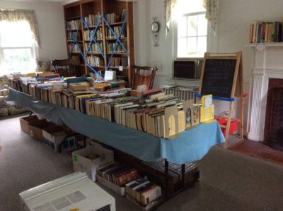 una mesa larga es llena de libros que están a la venta