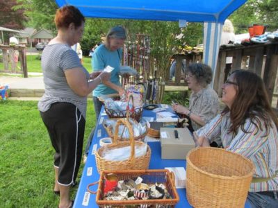 women browse a table of jewelry